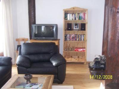 uma sala de estar com uma cadeira de couro e uma televisão em Sport-Alpin-Wohnung-10 em Oberstdorf