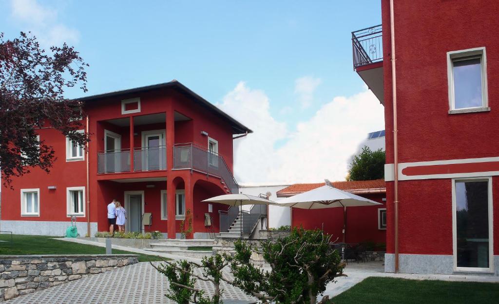 a red building with a person standing outside of it at Corte di Pellio in Pellio Superiore