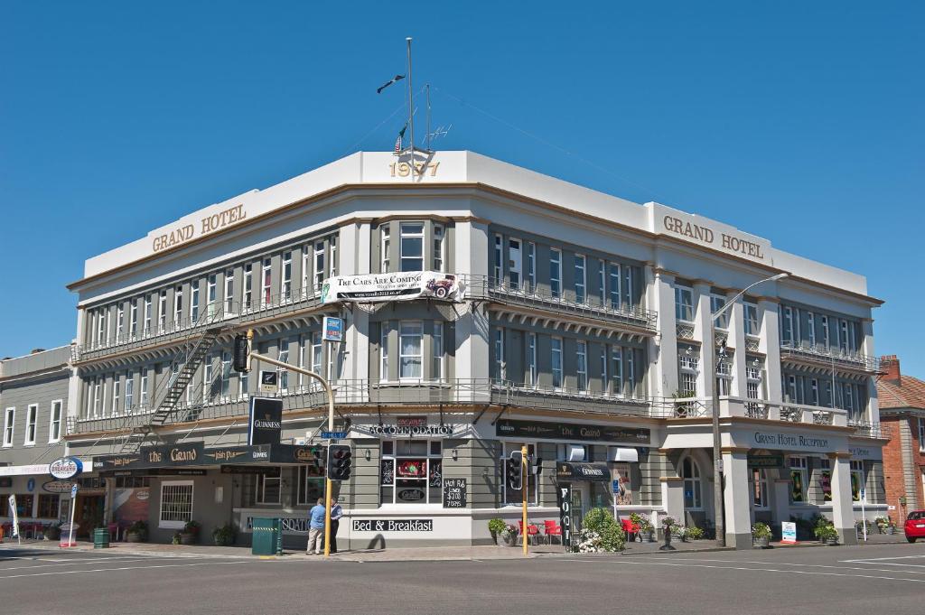 a large building on the corner of a street at The Grand Hotel Wanganui in Whanganui