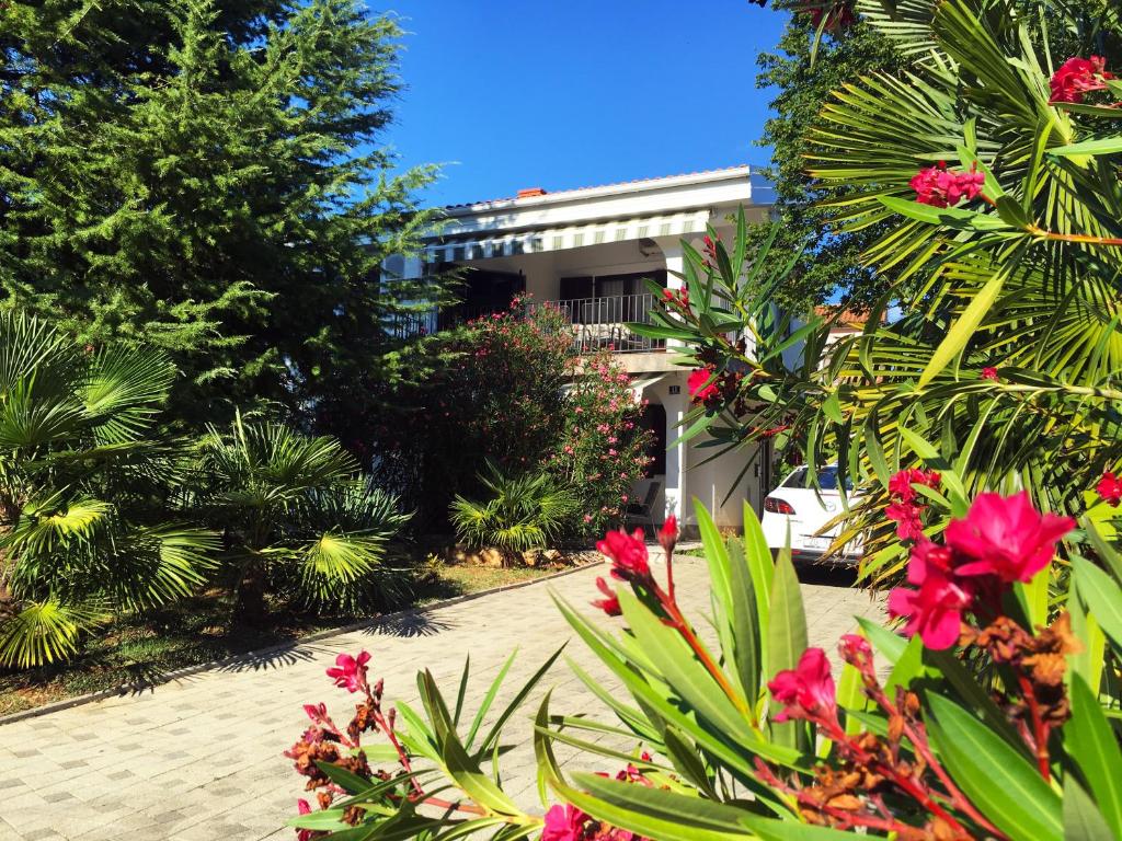 a garden with pink flowers in front of a building at Apartment Olive Groove in Malinska