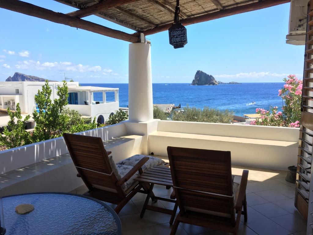 balcón con 2 sillas y vistas al océano en Hotel O Palmo en Panarea
