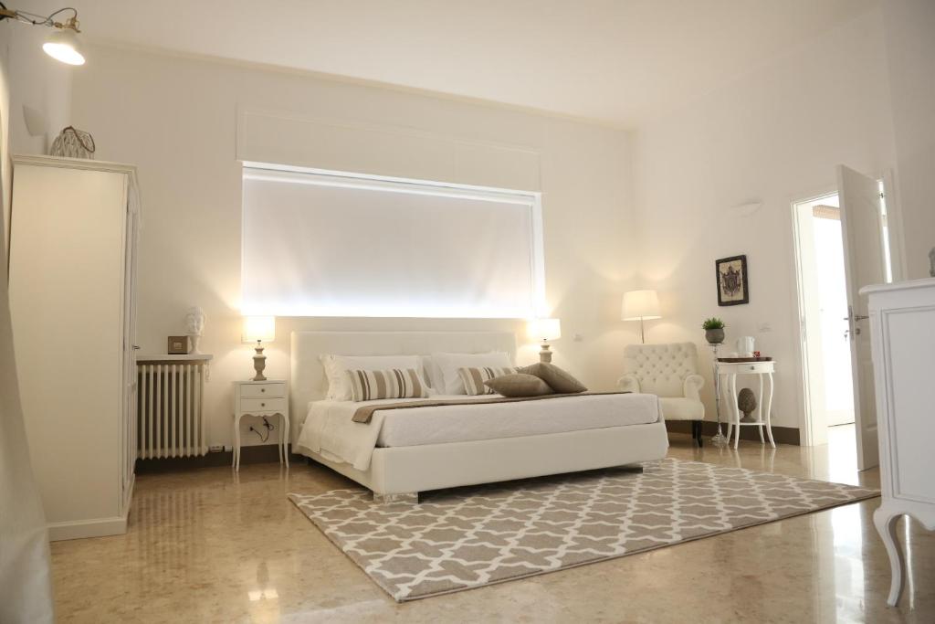 a white living room with a white bed and a rug at Dimi House in Lecce