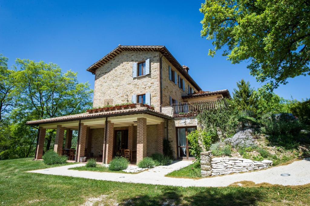 ein altes Steinhaus auf einem Hügel mit Bäumen in der Unterkunft Agriturismo La Corte del Lupo in Nocera Umbra