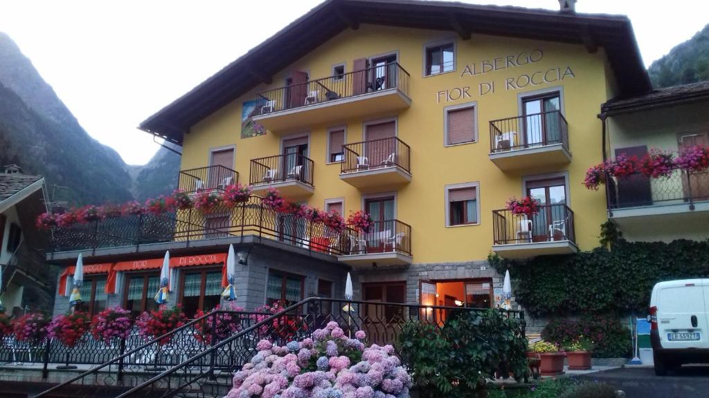 a yellow building with flowers in front of it at Hotel Fior di Roccia in Gaby