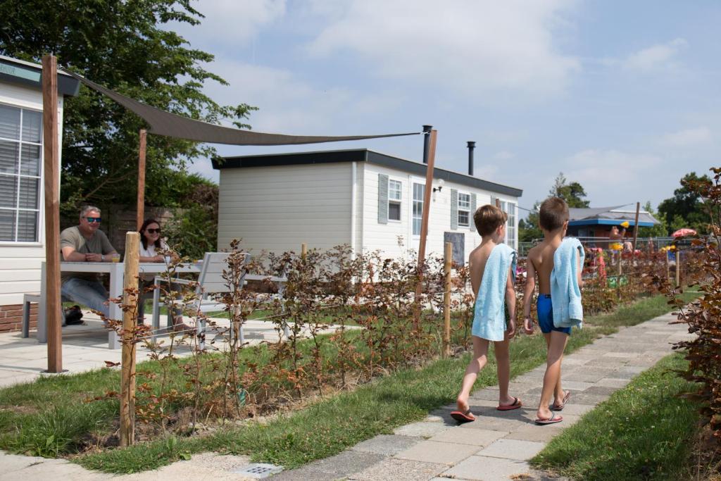 due bambini in piedi su un marciapiede in un giardino di Kleintje Beer a Baarland