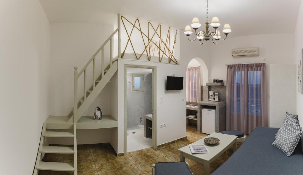 a living room with a spiral staircase and a living room at Viva Mare Traditional Studios in Astypalaia