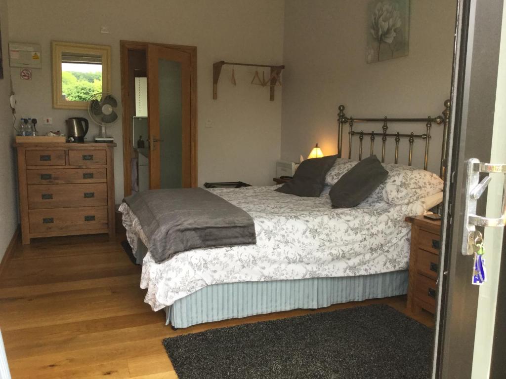 a bedroom with a bed and a dresser and a bed sidx sidx sidx sidx at Bryn Derw in Talsarnau