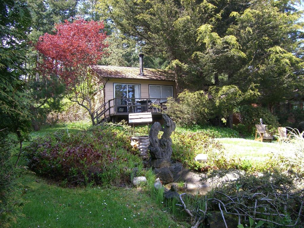 a small house in the middle of a garden at Driftwood Village Cottages in Sturdies Bay