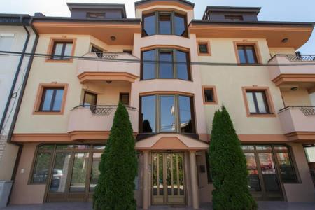 un gran edificio con árboles delante de él en Kukunesh Apartments en Ohrid