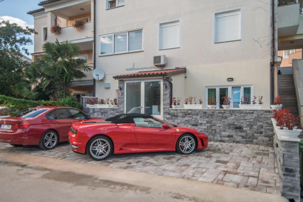 dwa czerwone samochody zaparkowane przed domem w obiekcie Hotel Boutique Natka w Rovinj