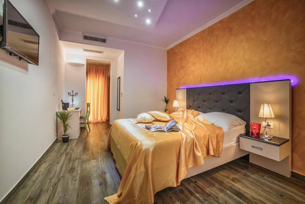 a bedroom with a large bed with a purple lighting at Hotel Boutique Natka in Rovinj