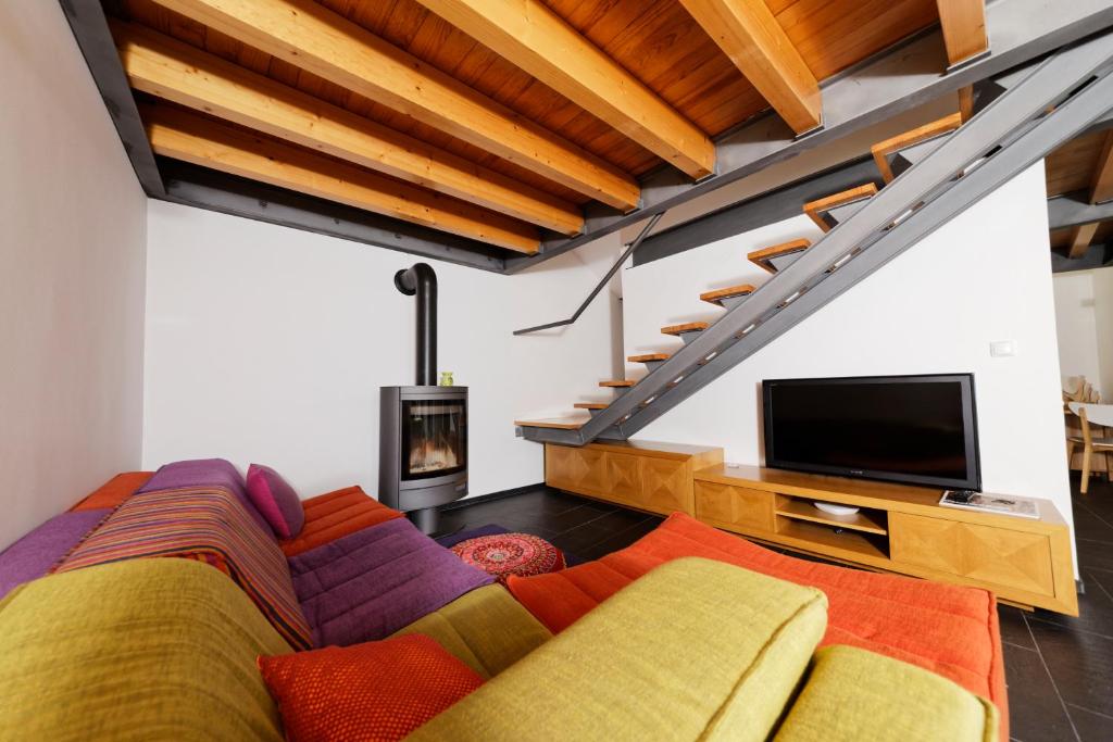 a living room with a couch and a flat screen tv at Antiga Casa da Burra in Viseu