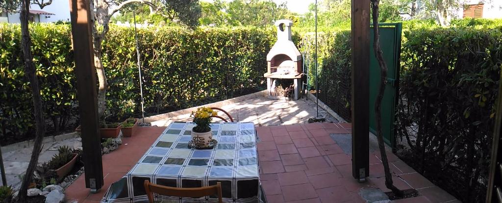un tavolo e sedie in un giardino con tavolo e una TV satellitare di Casa a Villaggio Paradiso a Santa Cesarea Terme