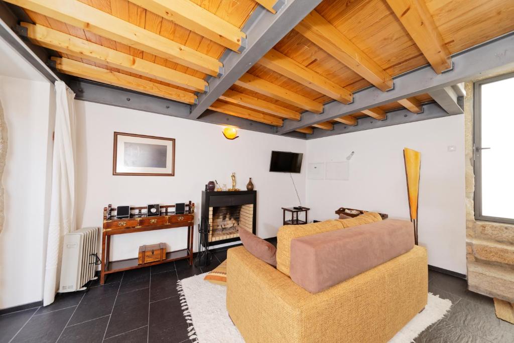 a living room with a couch and a fireplace at Antiga Casa do Boi in Viseu