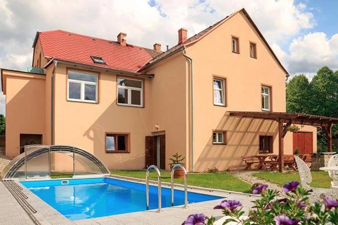una casa con piscina frente a una casa en Domek U rybníčku en Krásná Lípa