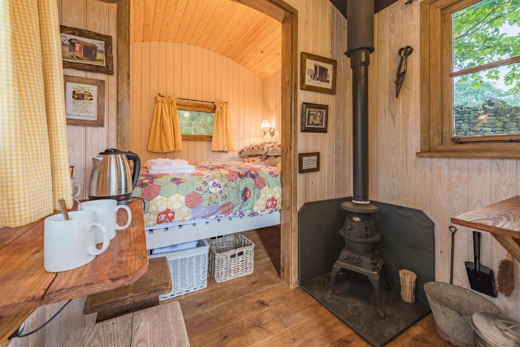 a bedroom with a bed and a stove in a room at Craven Shepherd Huts in Appletreewick