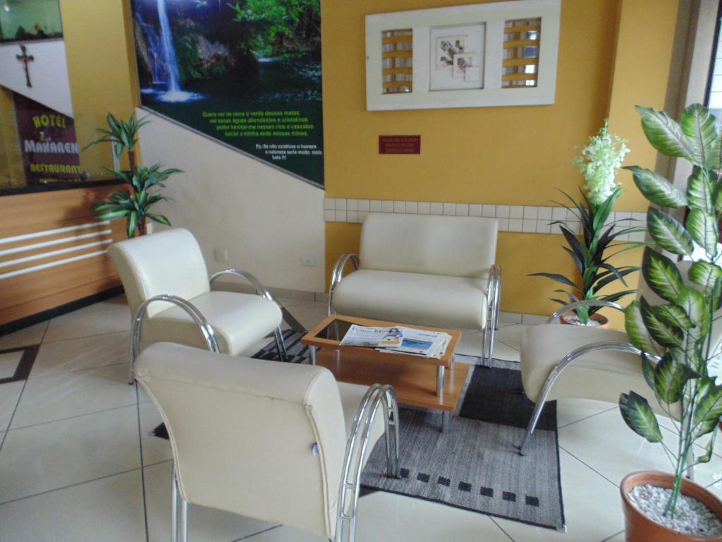 a waiting room with chairs and a table at Hotel Makarena in Três Corações