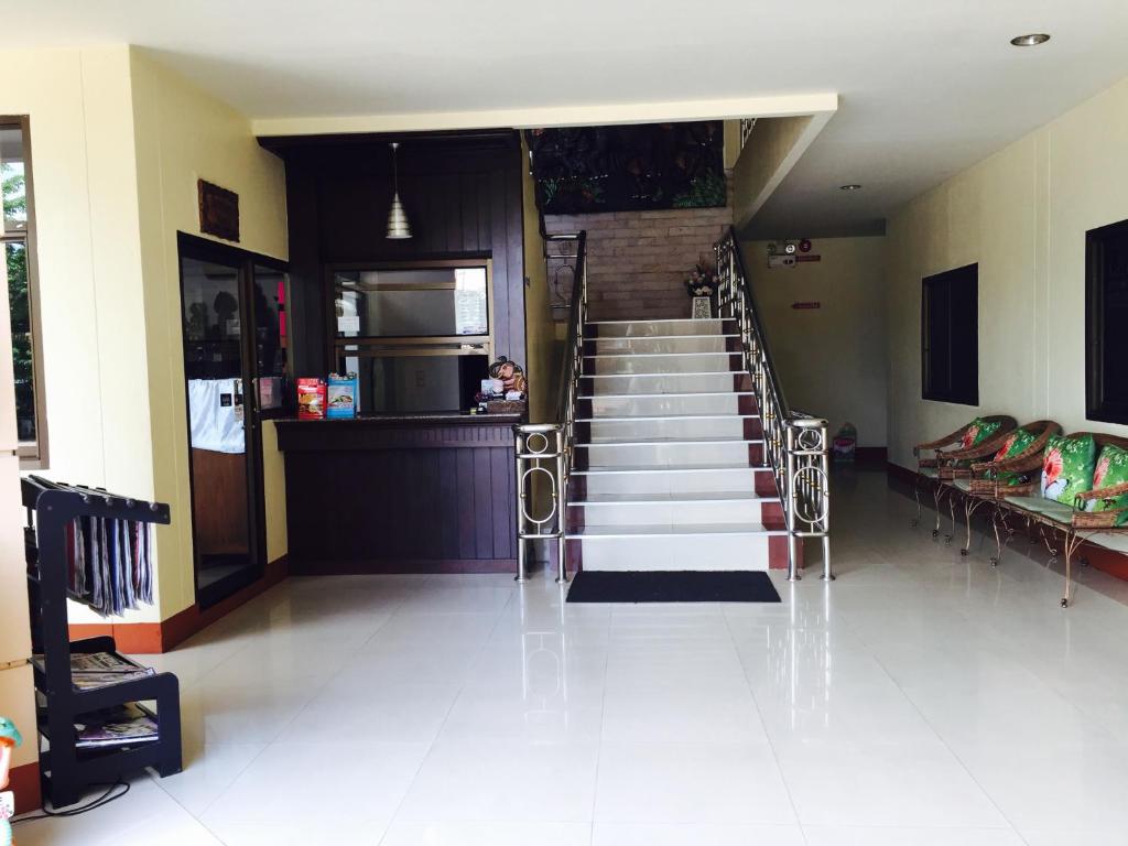a staircase in a building with a person sitting at the counter at Panchan Place in Ubon Ratchathani