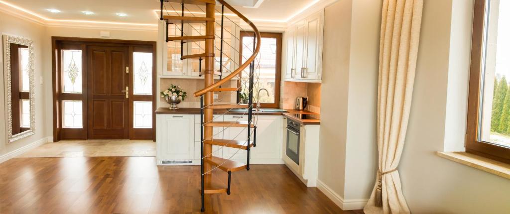 a kitchen with a spiral staircase in a home at Apartamenty Euphoria in Gołdap