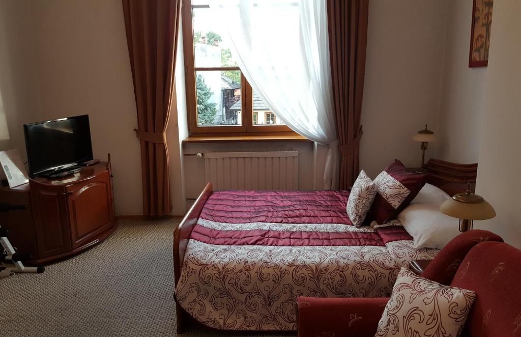 een hotelkamer met een bed en een raam bij Hotel Bristol in Tarnów