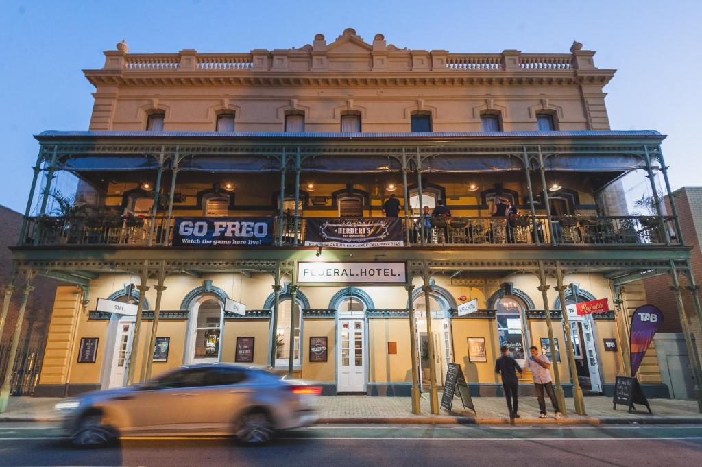 a car driving past a building with a balcony at The Federal Boutique Hotel in Fremantle