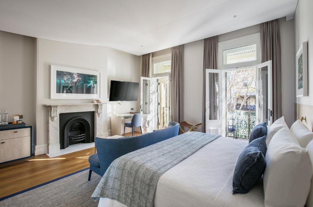 1 dormitorio con 1 cama grande y chimenea en Spicers Potts Point en Sídney