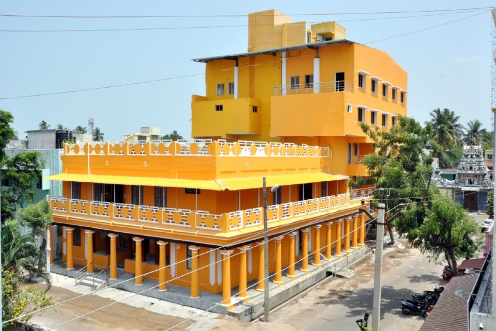 ein gelbes Gebäude mit Balkon darüber in der Unterkunft Hotel Anandhiram Heritage in Kāraikāl