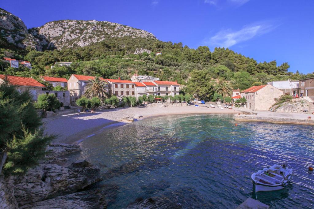 a beach with a boat in a body of water at Apartment Feral in Orebić
