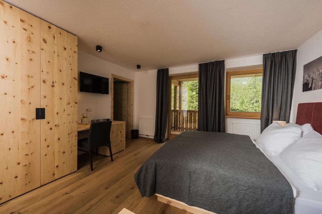 Postel nebo postele na pokoji v ubytování Hotel Dolomitenhof & Chalet Alte Post