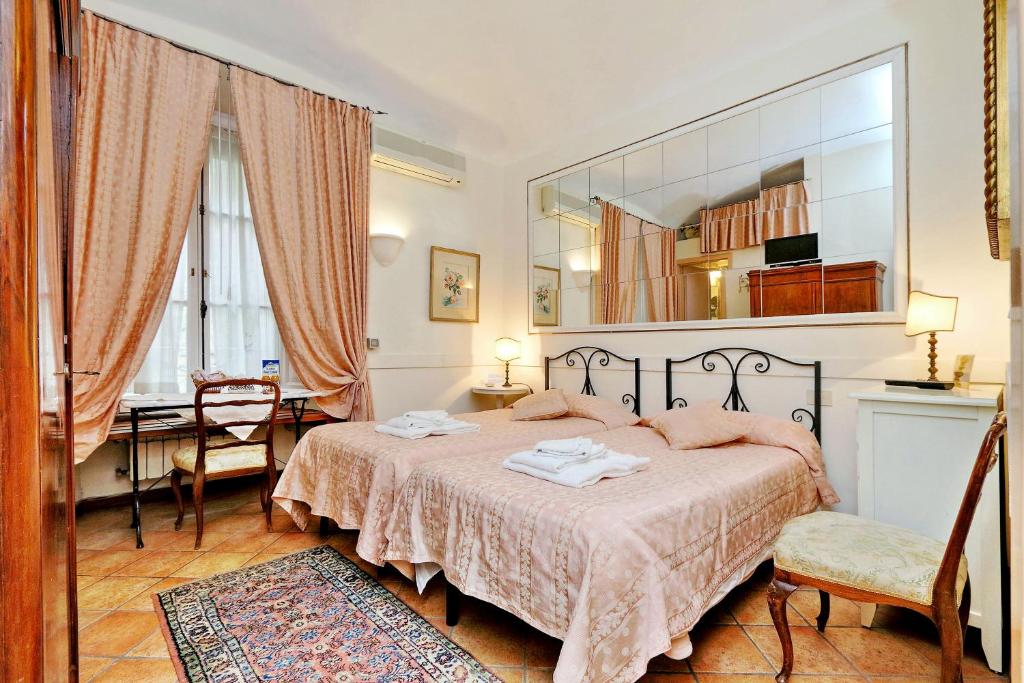 a bedroom with a bed and a table and a mirror at Scipioni Suites in Rome