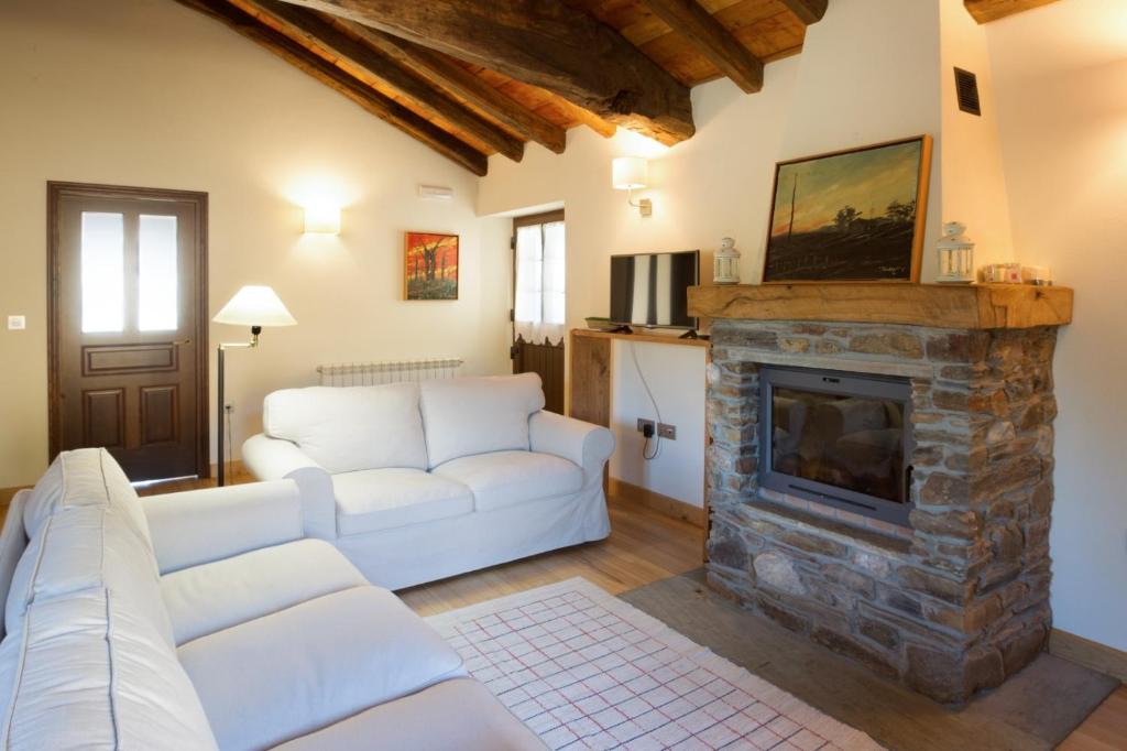 a living room with a couch and a fireplace at Casa Remedios in Villarquille