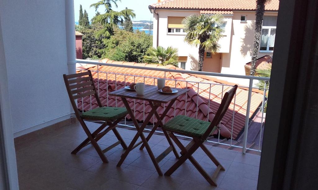 einen Tisch und zwei Stühle auf dem Balkon in der Unterkunft Apartment Tip Top in Rovinj