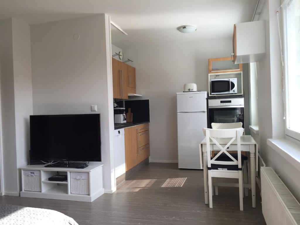 a kitchen with a television and a table with a chair at City Apartment Maaherrankatu, ilmainen kadunvarsipysäköinti in Kuopio