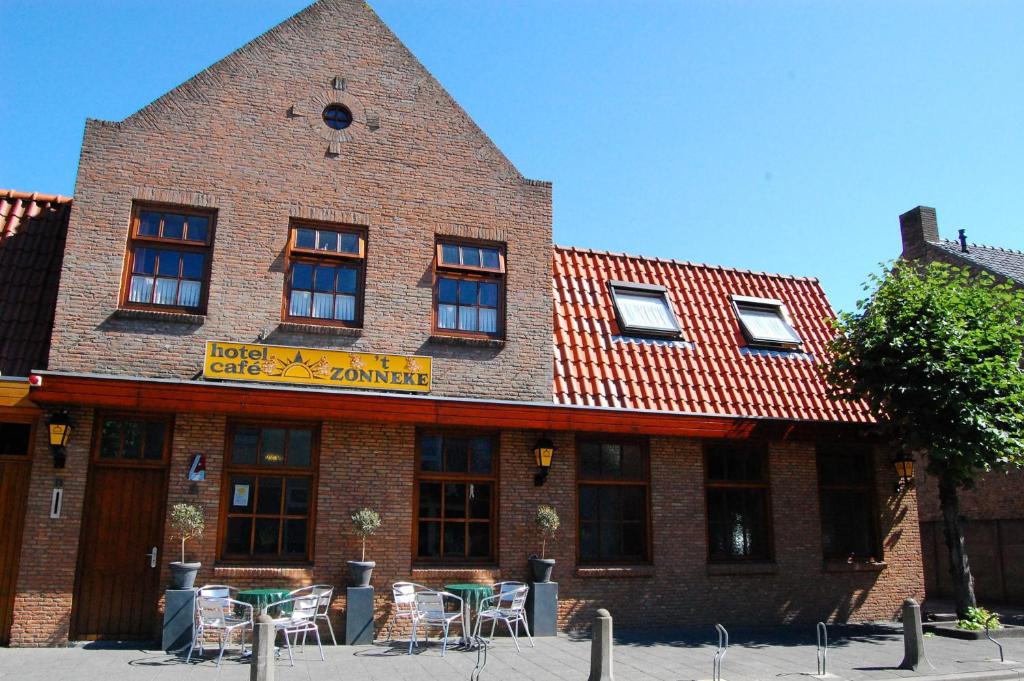 un edificio de ladrillo con mesas y sillas delante de él en Hotel Cafe 't Zonneke, en Oosterhout