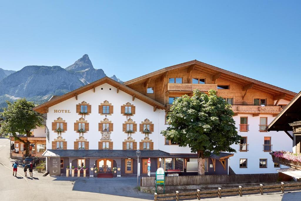 een groot gebouw voor een berg bij der grüne Baum Mountain Boutique Hotel in Ehrwald