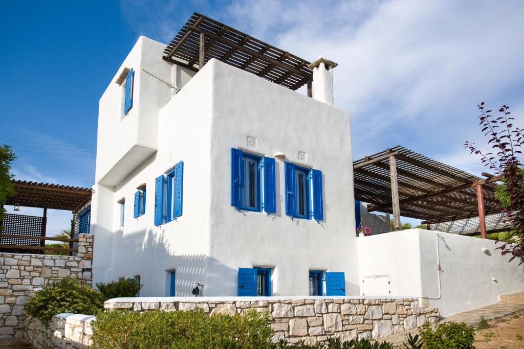 クリシ・アクティにあるVilla Yviskos Traditional Homeの青窓と石壁の白い家