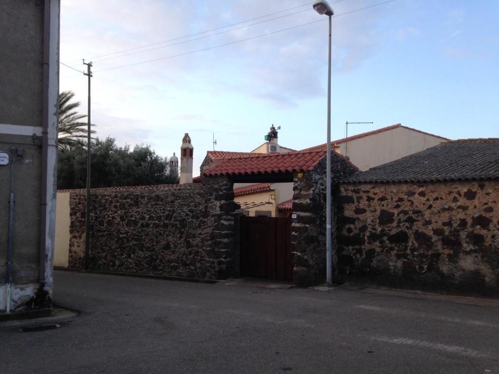 La casa di Sergio في Bauladu: جدار حجري مع بوابة ومبنى