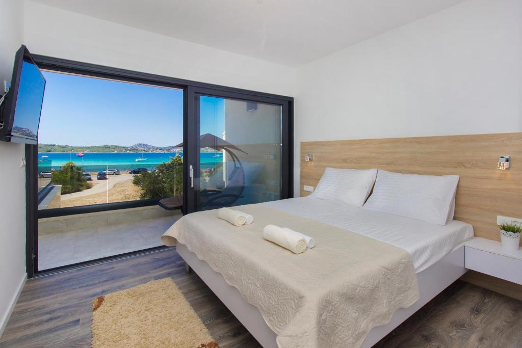 a bedroom with a bed and a large window at Villa Eden in Srima