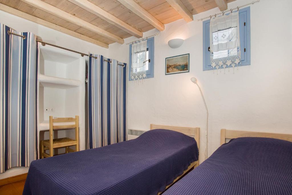 sypialnia z fioletowym łóżkiem i oknem w obiekcie Villa Yviskos Traditional Home w mieście Chrissi Akti