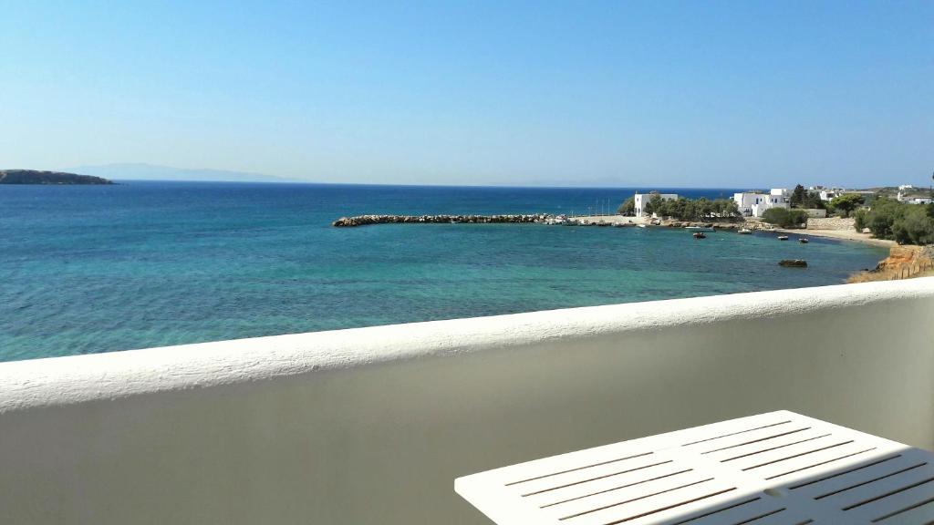 a white chair sitting on a balcony overlooking the ocean at Kleanthi Apartments in Drios