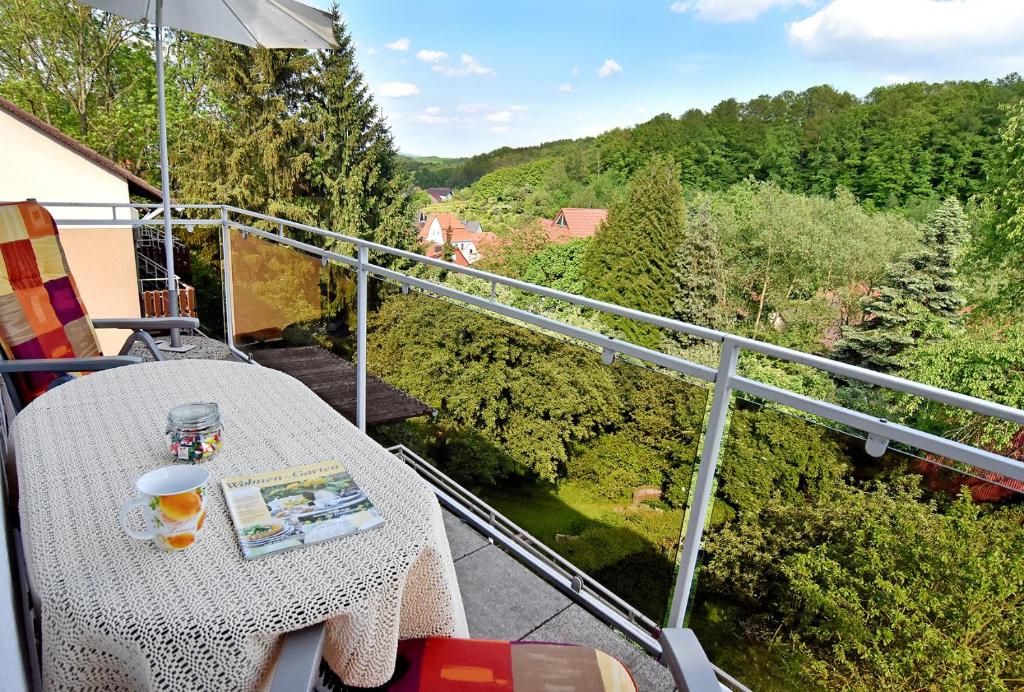 balcón con mesa y vistas a los árboles en Ferienwohnung Dommes en Fuhrbach