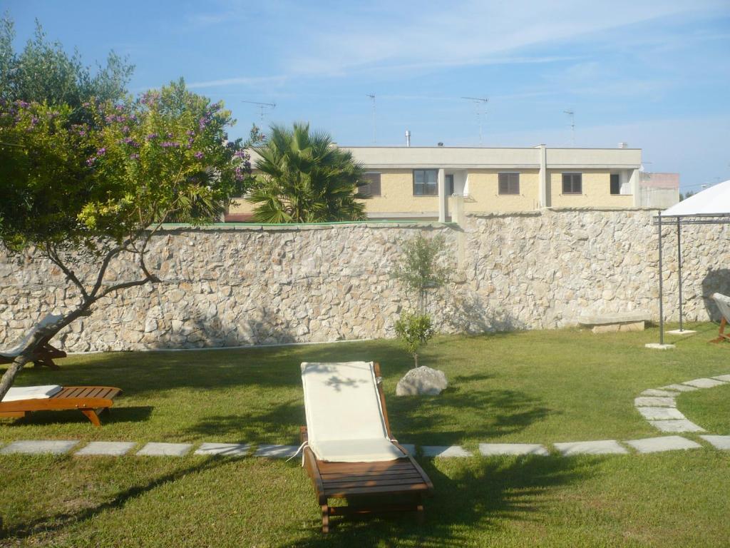 オートラントにあるLa casa del contadinoの石壁とベンチのある庭