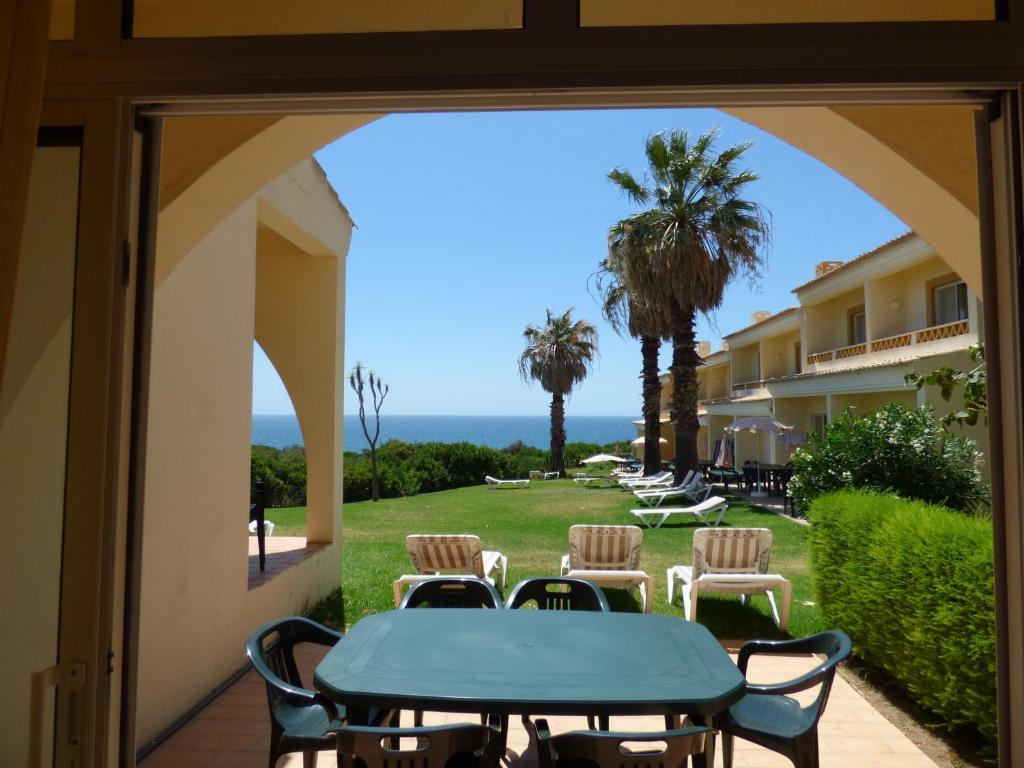 a patio with a table and chairs and a view of the ocean at Pestana Palm Gardens in Carvoeiro