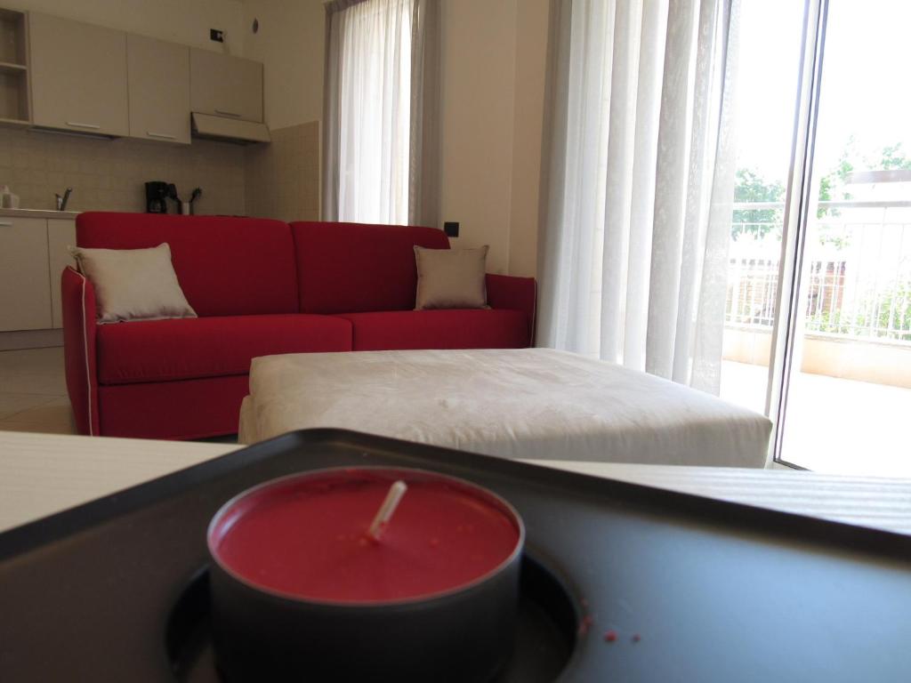 - un salon avec un canapé rouge et un lit dans l'établissement Bludamare, à Albenga