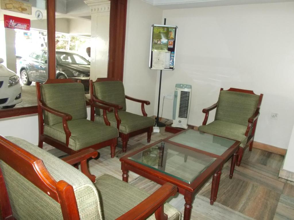 a waiting room with chairs and a coffee table at Biju's Tourist Home in Cochin