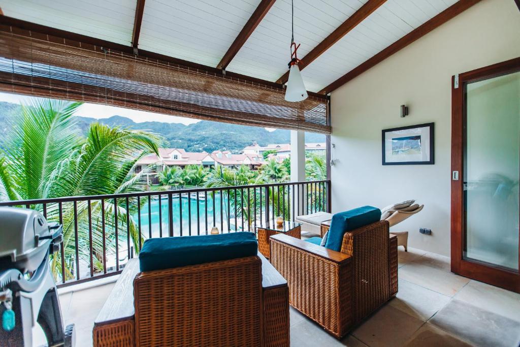 d'un balcon avec des chaises en osier et une vue sur l'océan. dans l'établissement Aquamarine, à Eden Island