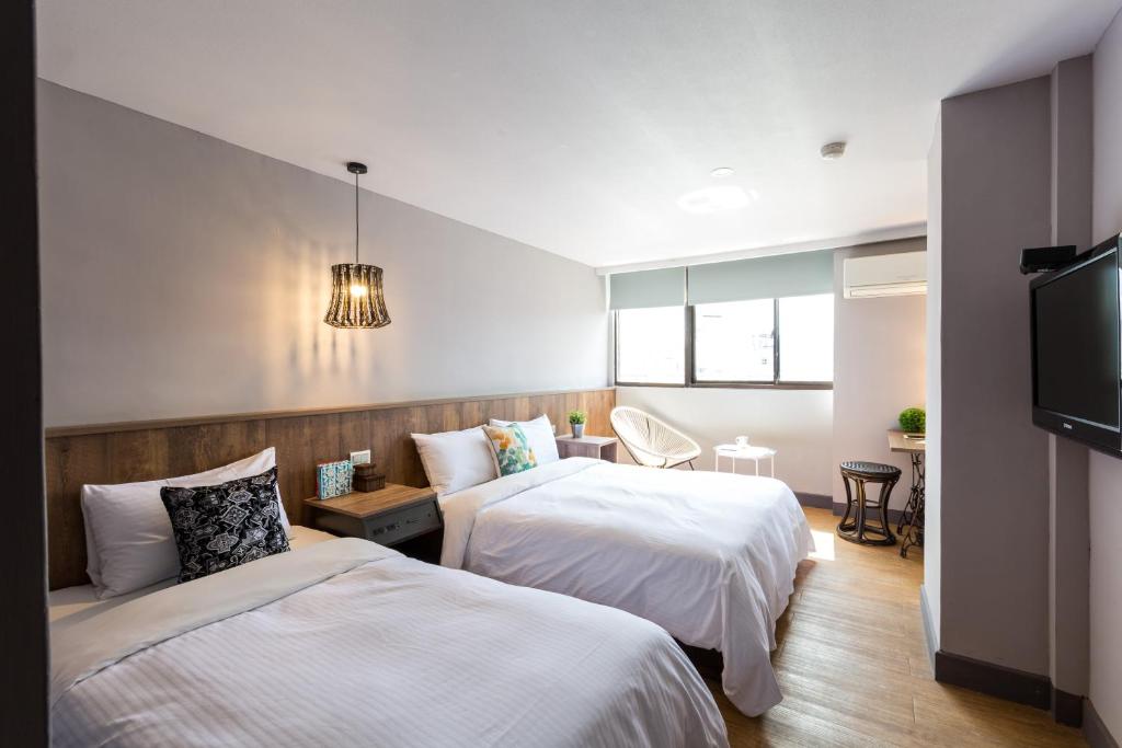 a hotel room with two beds and a flat screen tv at 樂亞亞奇文旅 in Luodong