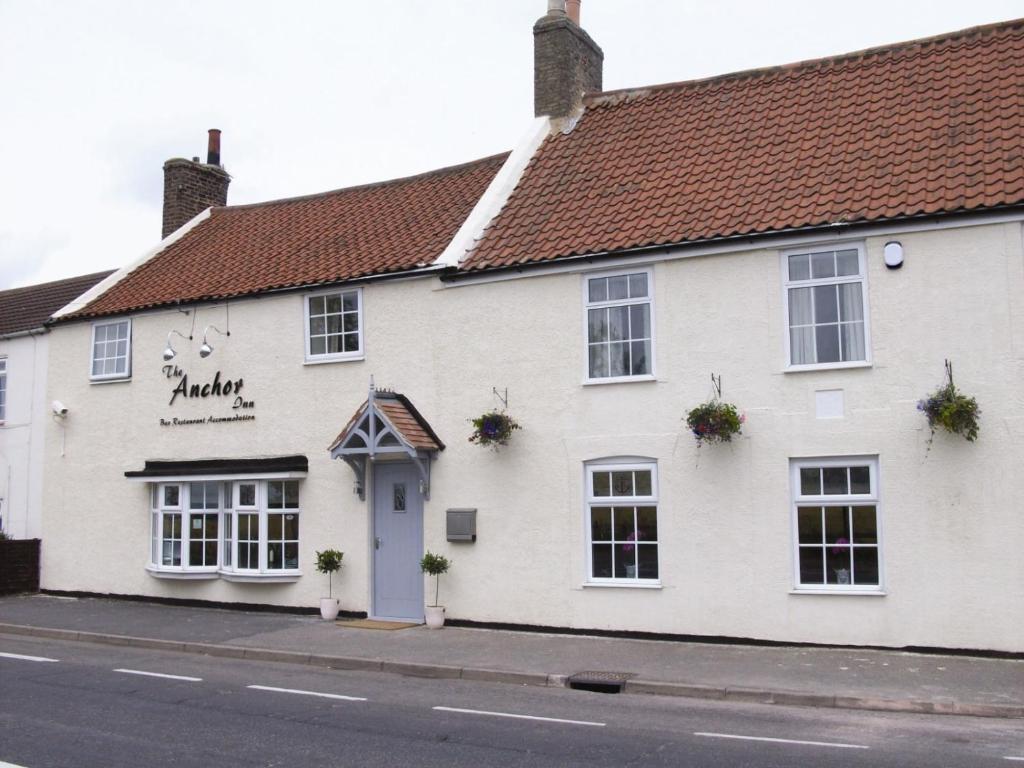 um edifício branco ao lado de uma rua em The Anchor Inn em Sutton Bridge