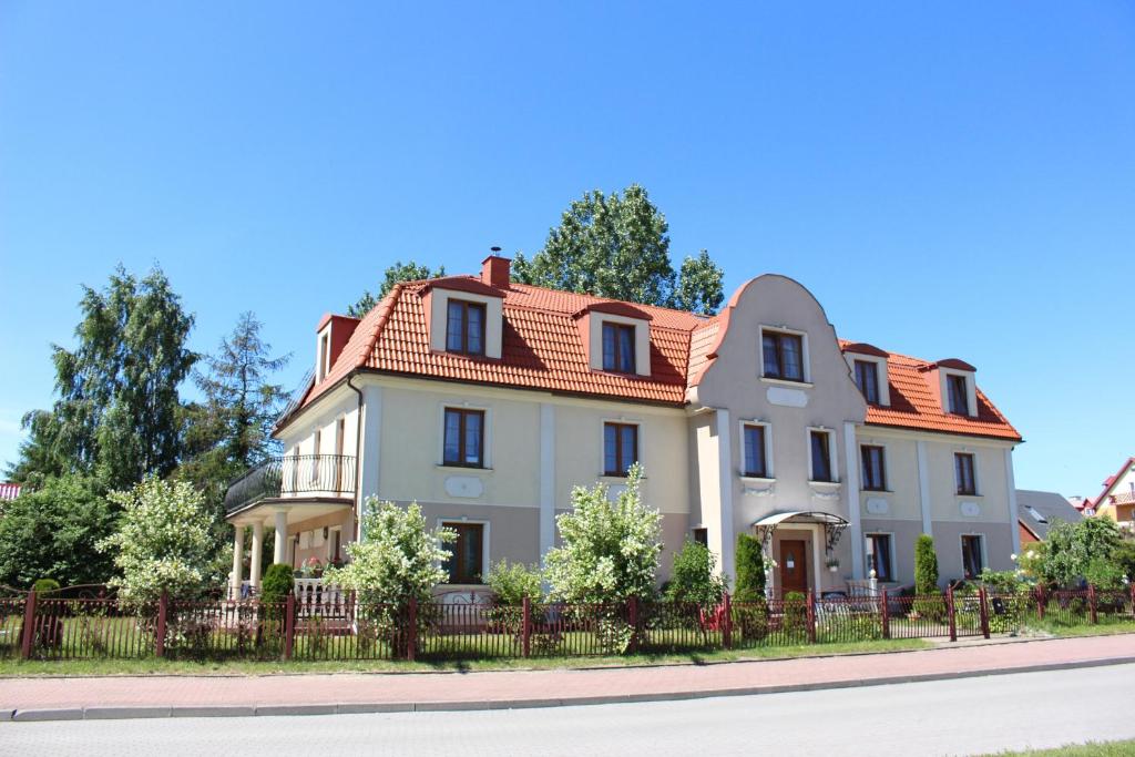 a large white house with a red roof at Willa Tradycja in Łeba