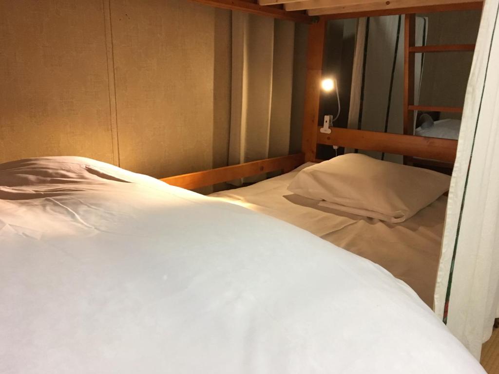 Tempat tidur dalam kamar di Guest House YAMASHITA-YA